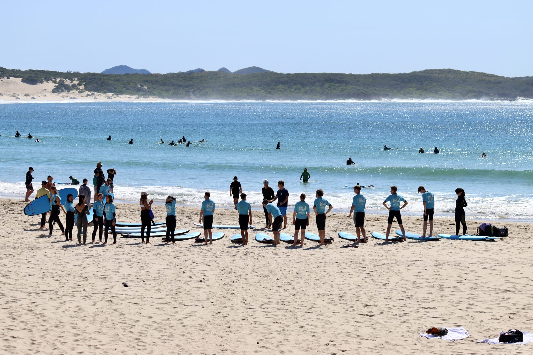 Group of surfers walking to the water at Port Stephens Surf School